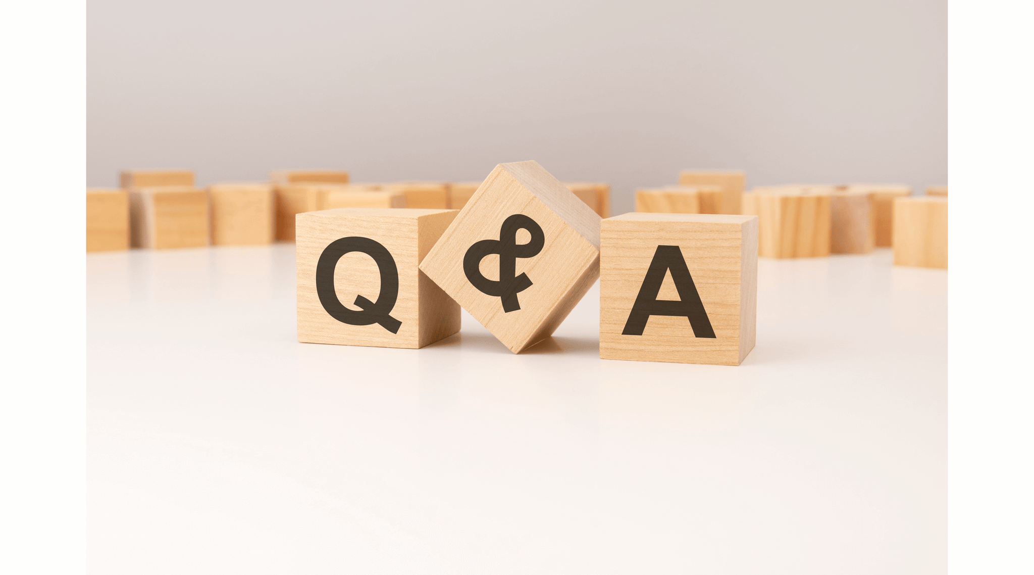 Three wooden cubes with Q and A symbols on them.