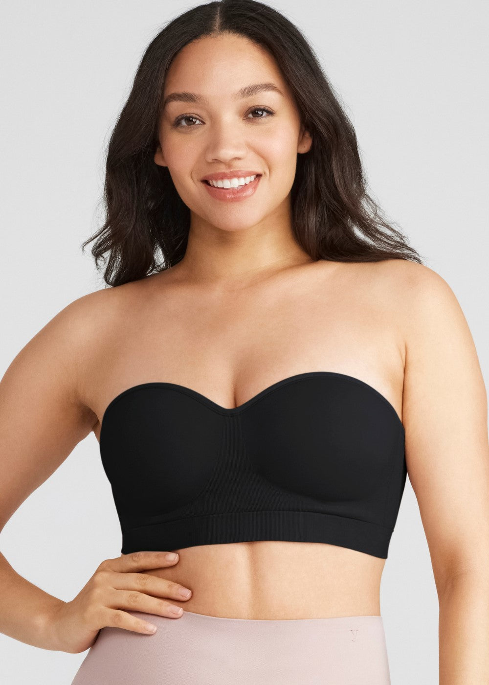 peyton contour strapless convertible bra in Black worn by a woman facing forward with one hand at waist Yummie