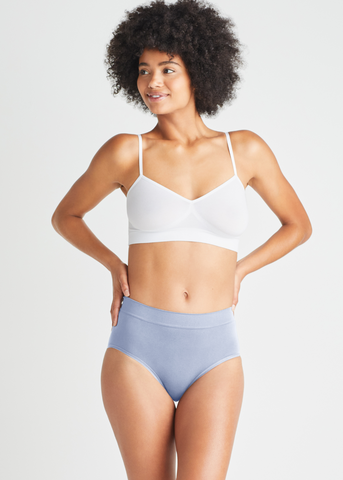 non-shaping retro brief - seamless in Halogen Blue with audrey unlined bralette - outlast® seamless in White worn by girl with hands on hips. Yummie.