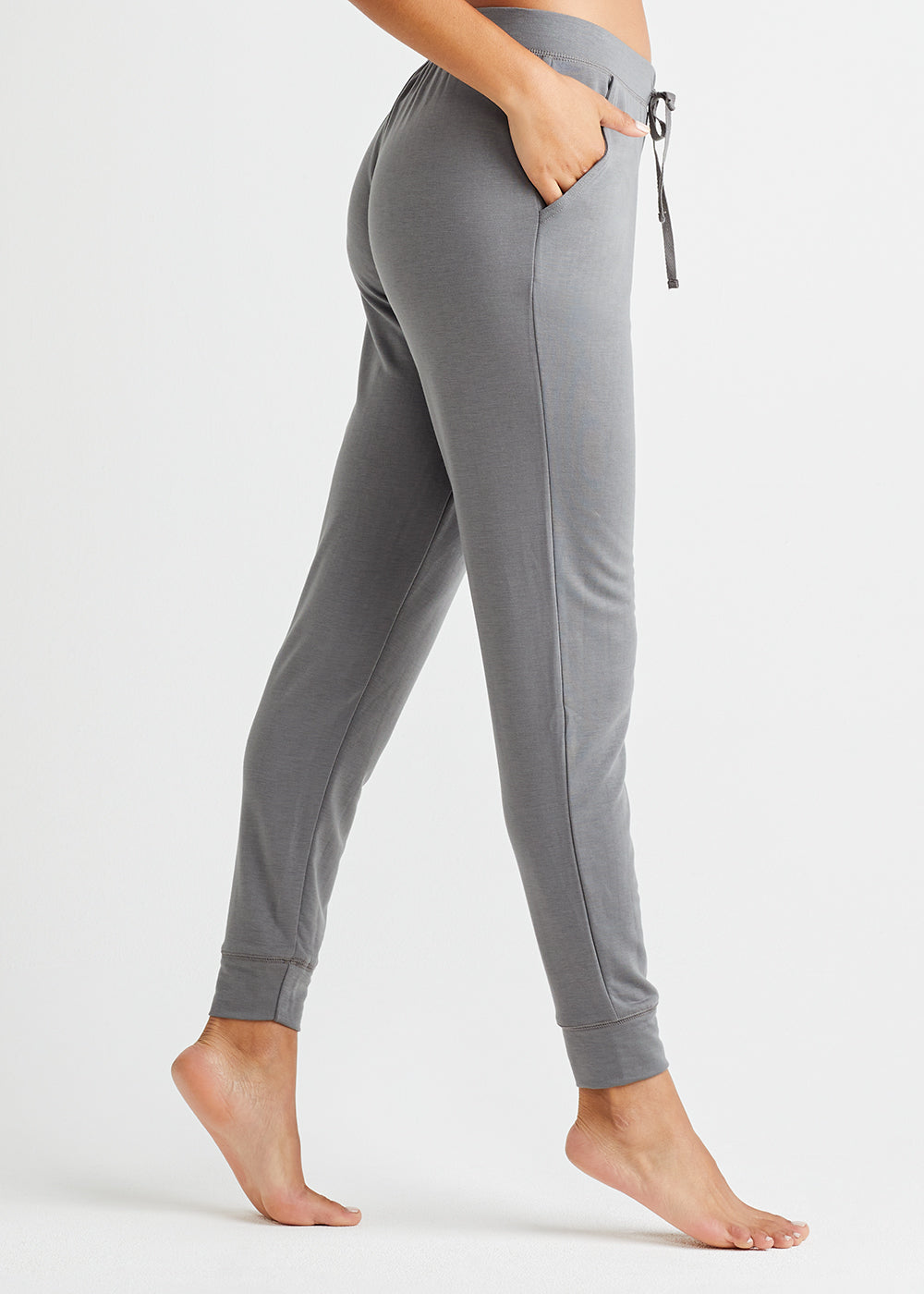 slim leg lounge jogger - baby french terry in Gargoyle with Pockets worn by a woman standing sideways Yummie