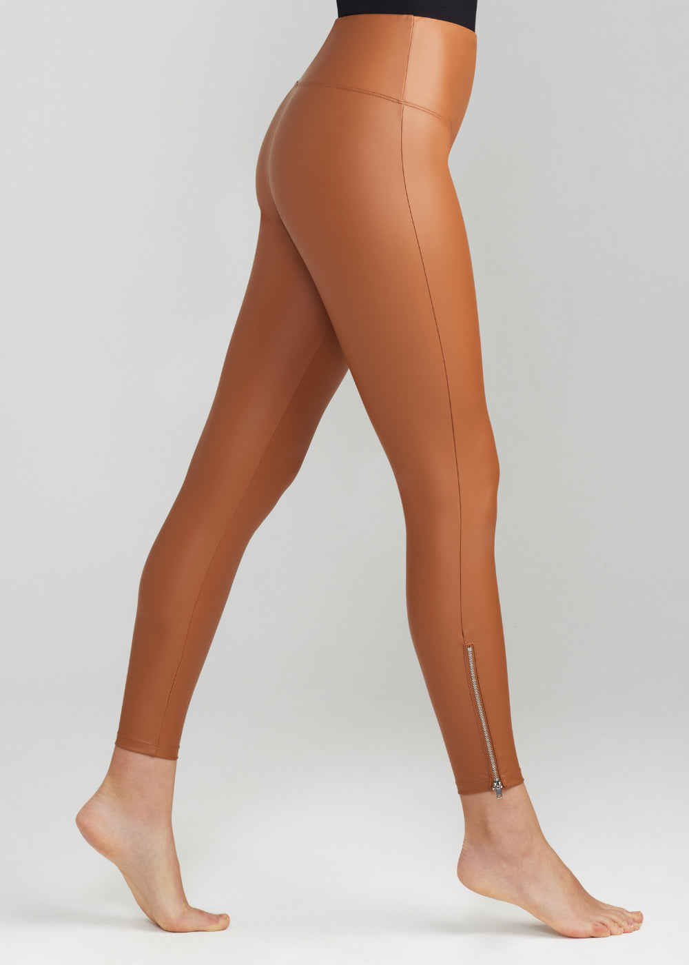 faux leather shaping legging with side zip in Rawhide Tan worn by a woman standing sideways Yummie