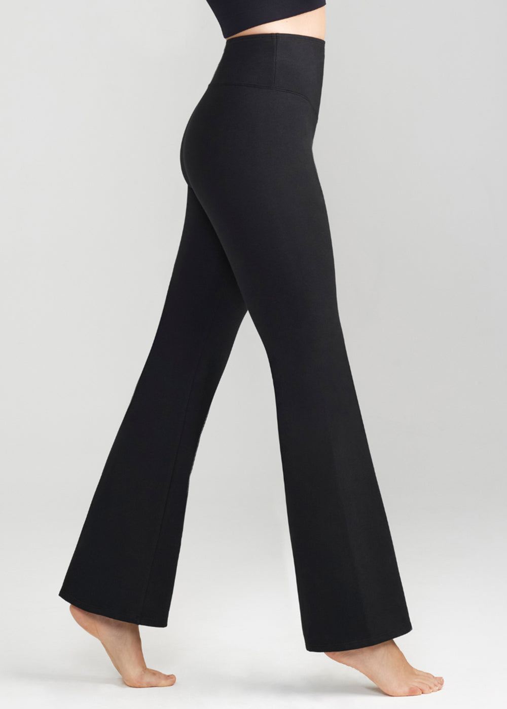 susie flare shaping legging - cotton stretch in Black worn by a woman standing sideways Yummie