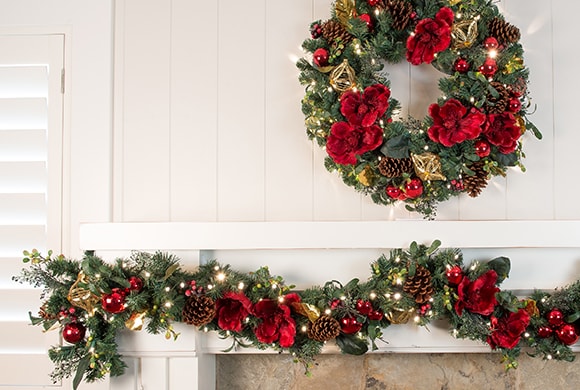 Red Magnolia Wreath and Garland Hanging Above Fireplace Mantle