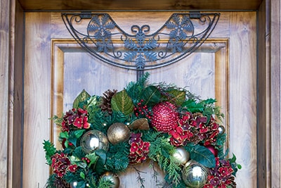 Village Lighting Wreath Hanger on door with scarlet hydrangea wreath