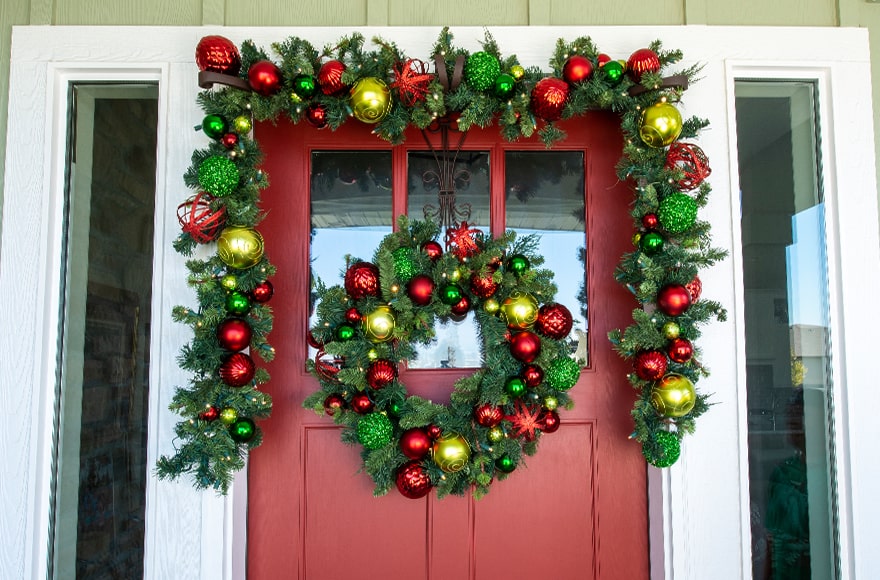 Festive Holiday Wreath and Garland Hanging On Front Door