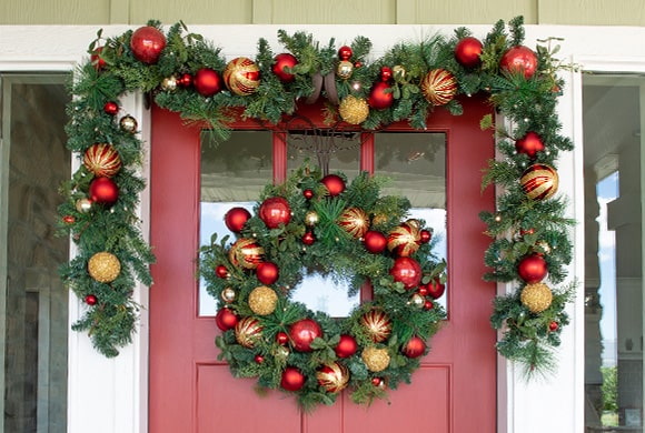 Christmas Classic Red and Gold Wreath and Garland Hanging On Front Door