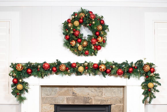 Christmas Classic Red and Gold Wreath and Garland Hanging Above Fireplace Mantle