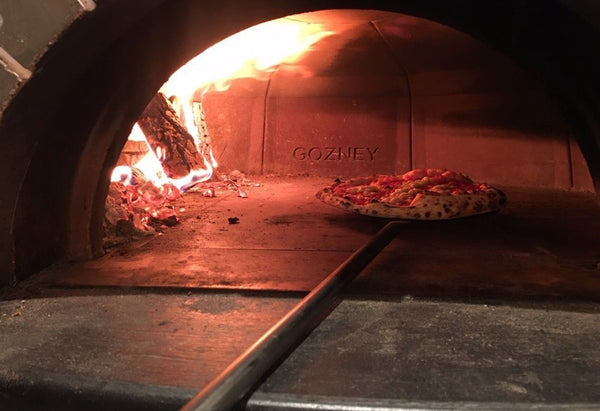 Gozney dome pizza oven fueled by kiln-dried Gozney wood