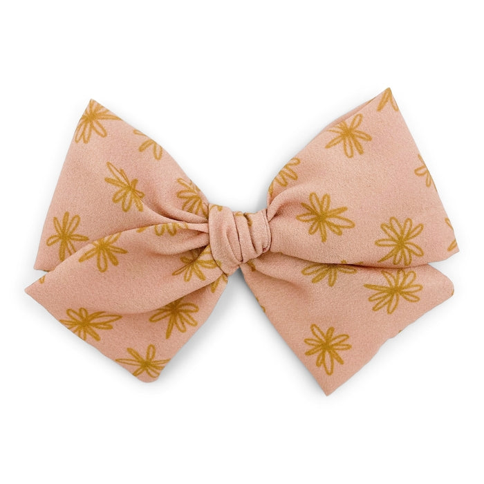 The Kindred Studio golden daisies midi bow against white backdrop