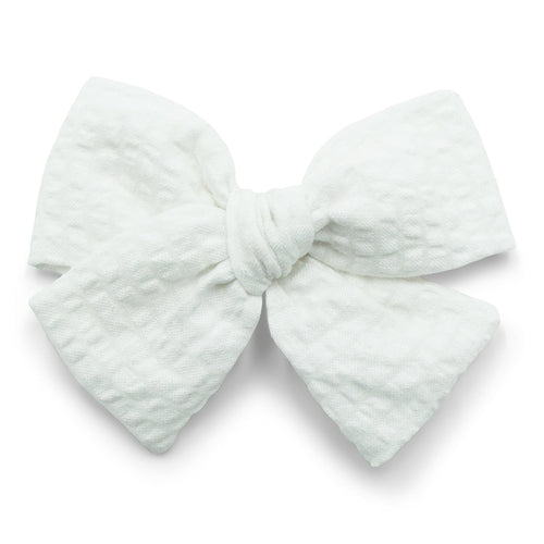 The Kindred Studio white midi bow against white backdrop