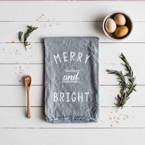 set of 2 grey 100 percent organic cotton hand printed Christmas holiday dishtowels for a farmhouse kitchen with merry and bright printed on them in white ink