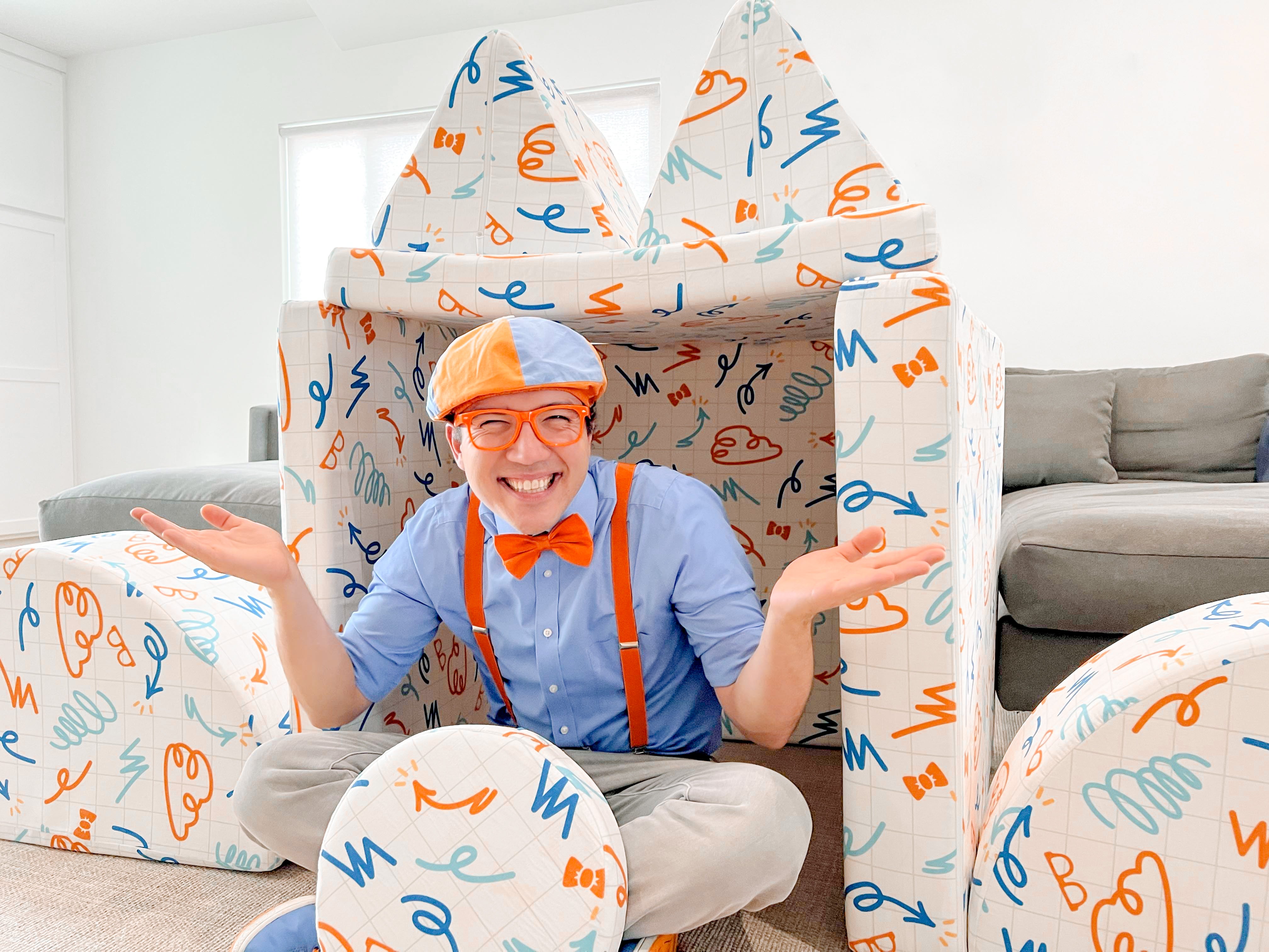 Blippi playing in his play couch fort