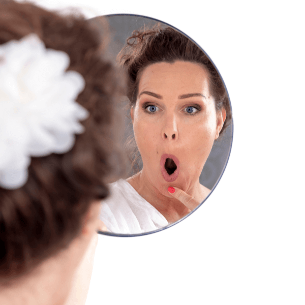 Woman doing facial exercises in mirror