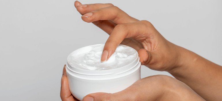 finger in a moisturizer jar