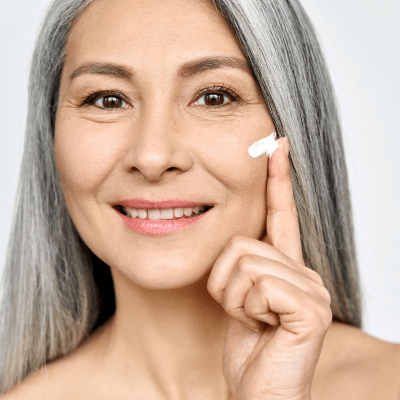 woman applying skincare to cheek