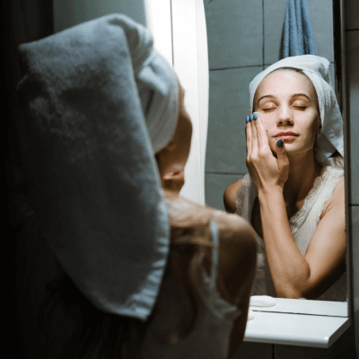 woman doing skincare in the mirror