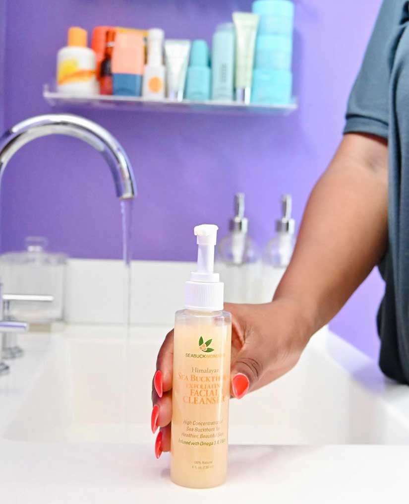 Blogger holding a bottle of SeabuckWonders Exfoliating Cleanser 