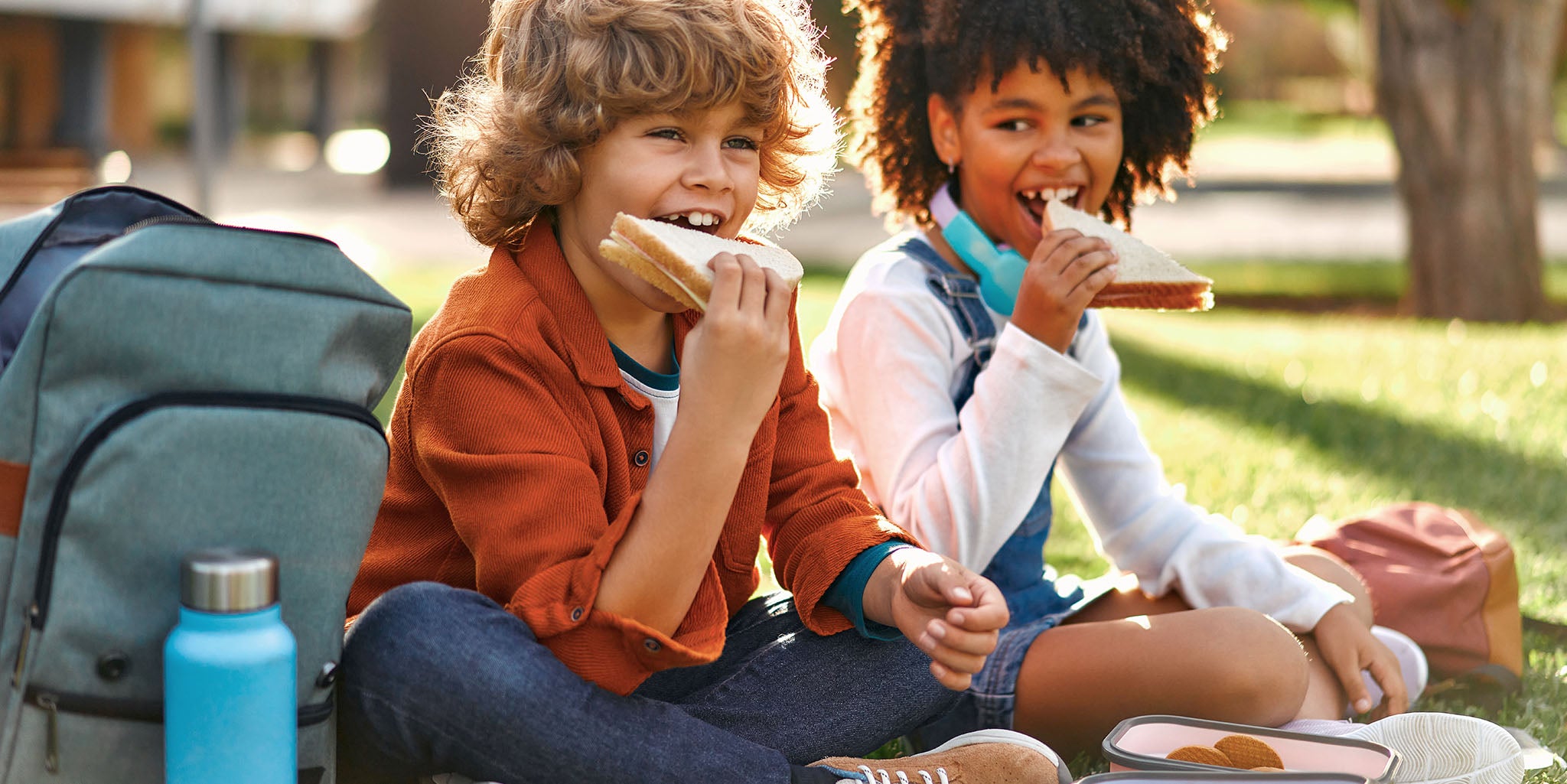 Two children eating a sandwich.