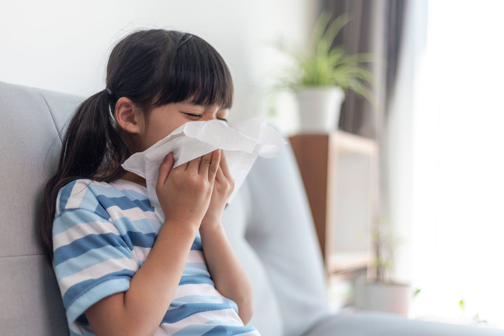 Child engaging in the healthy habit of coughing into a tissue.