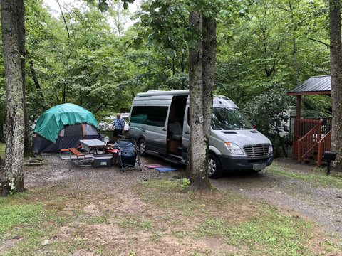 Van parked beside tent at campsite near the Great Smoky Mountains.