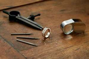 Jeweller working on a gold ring with diamonds on it