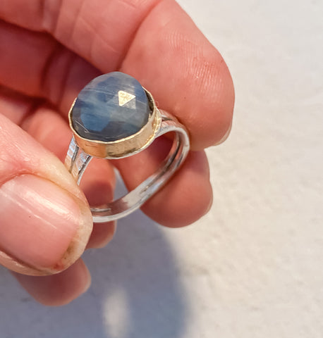 Blue Sapphire ring held between two fingers