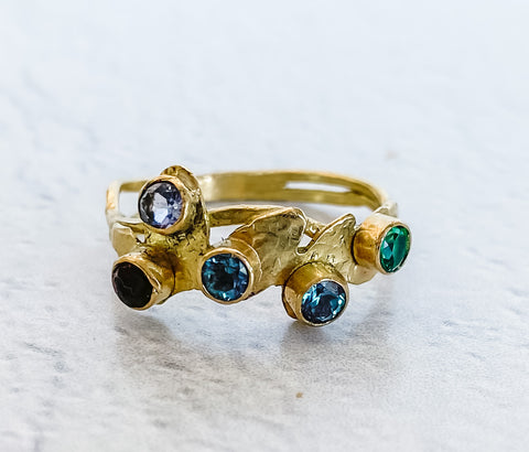 handcrafted 18 kt gold ring by Aprilierre Jewelry featureing two organic bands gold leaves with garnet, tanzenite, two  alexandrite and emerald