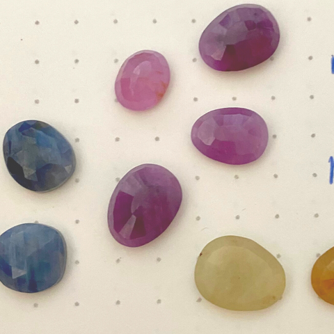 Rose cut sapphire gemstones scattered in blue, red and yellow collors