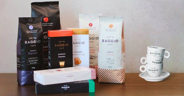 Kit de cafés Baggio com diversos pacotes de diferentes sabores de café, com três xícaras empilhadas ao lado.