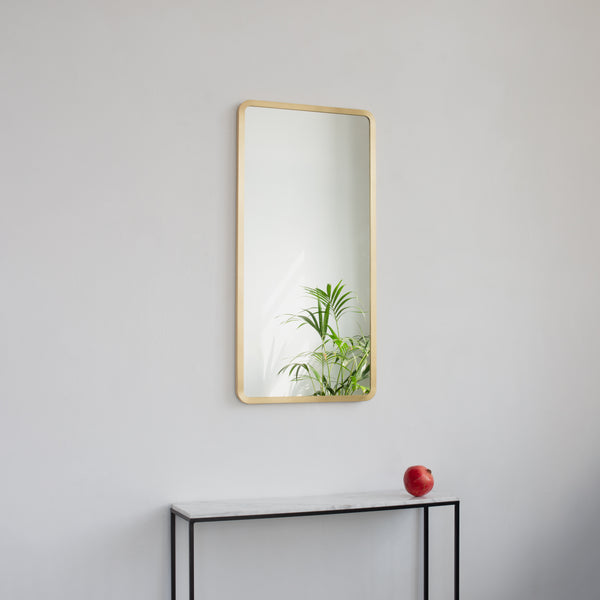 Modern rectangular mirror with an elegant solid brushed brass frame.