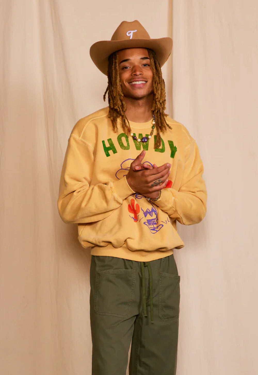 Male wearing brown sweatshirt with brown cowboy hat