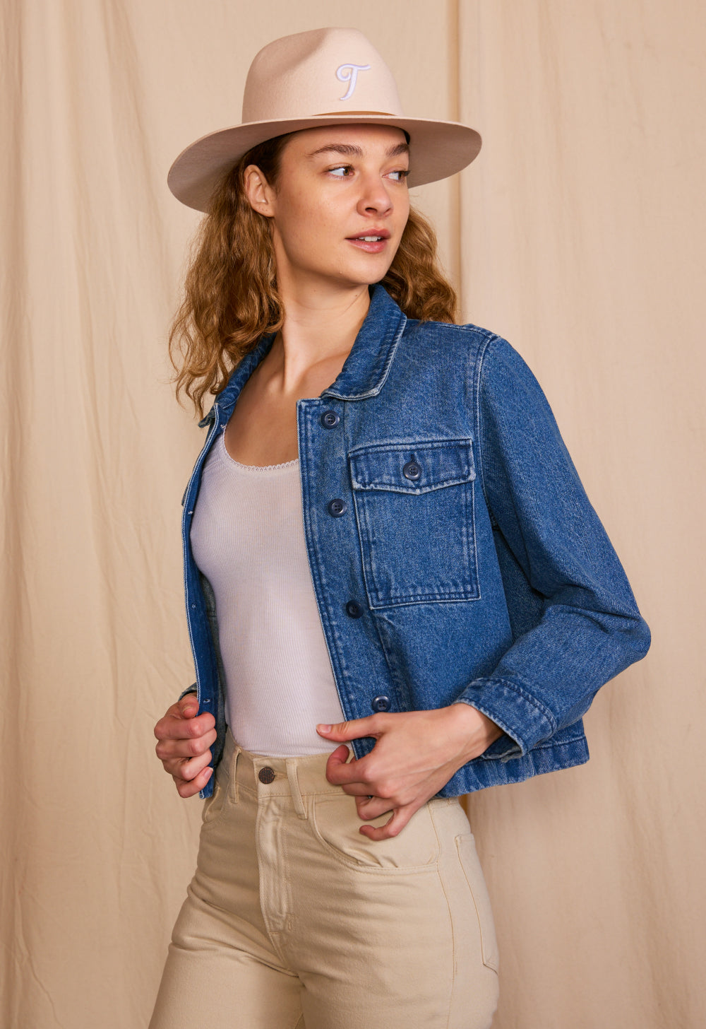 Woman wearing demin jacket with cowboy hat