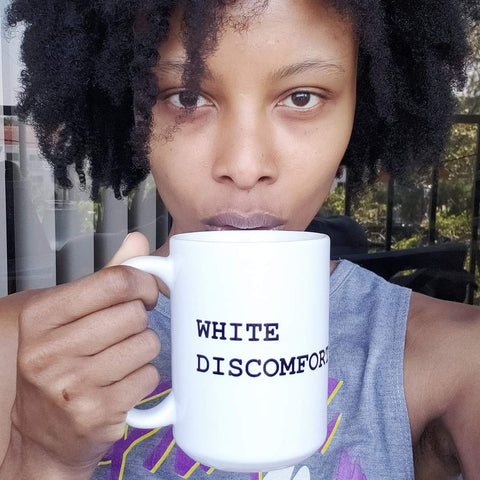 Alexandria Boddie holds a mug that says "White Discomfort"