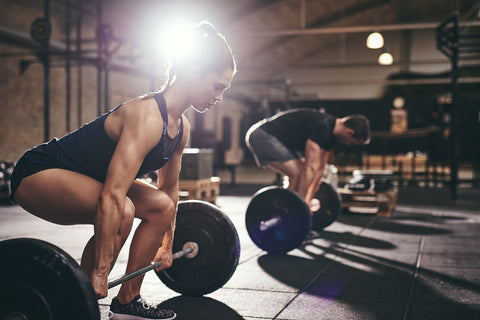 Man and woman doing deadlifts.