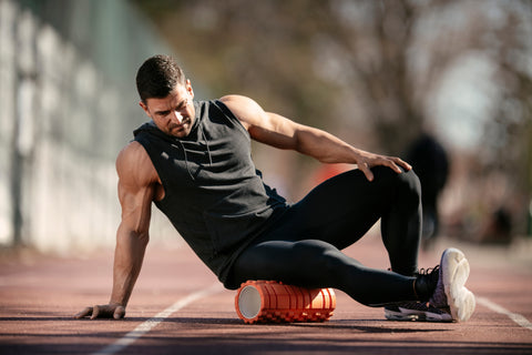 a man foam rolling his hamstrings