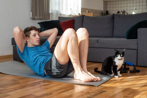 A teenager doing sit ups at home.