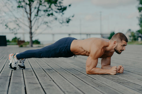 male athlete does plank exercise