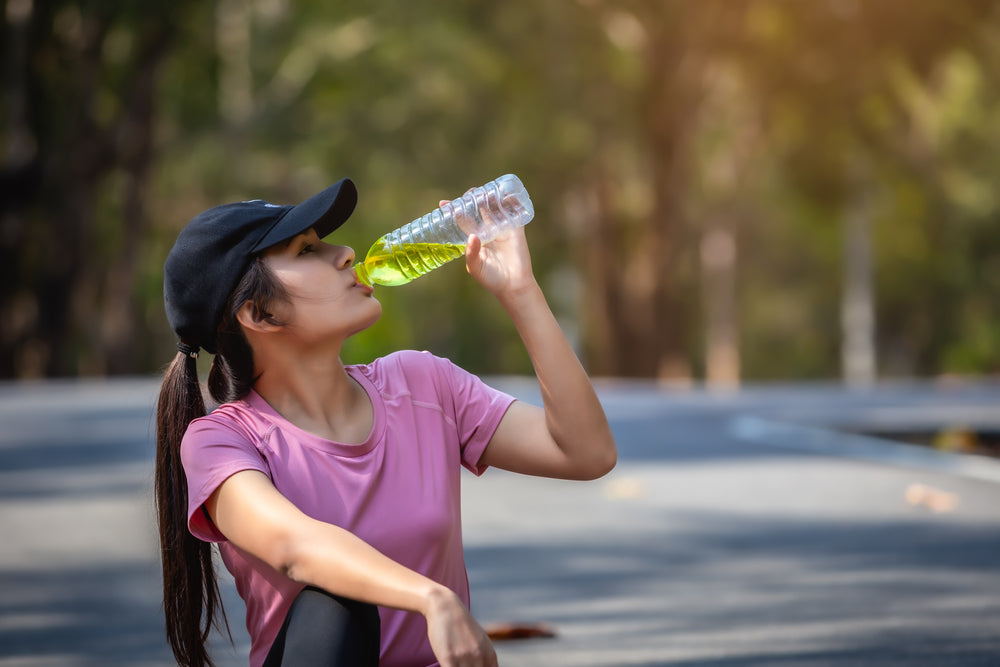 Close-up of beautiful asian woman sport athletes drinking water with electrolytes after exercise