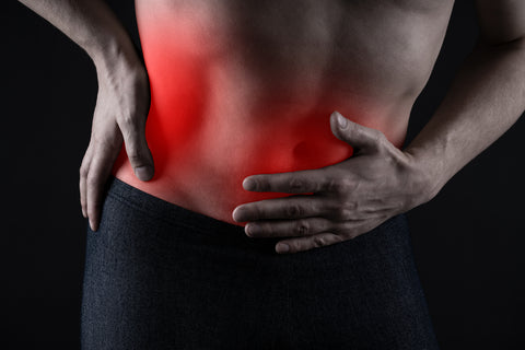 Man with abdominal pain, stomach ache on black background,