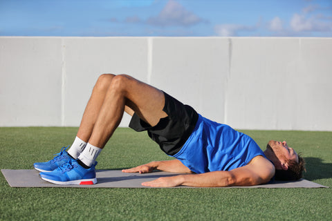 man doing bodyweight glute floor bridge