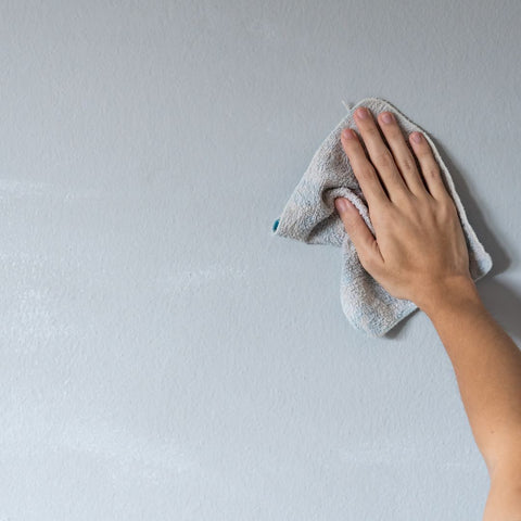 Someone washing wallpaper on wall