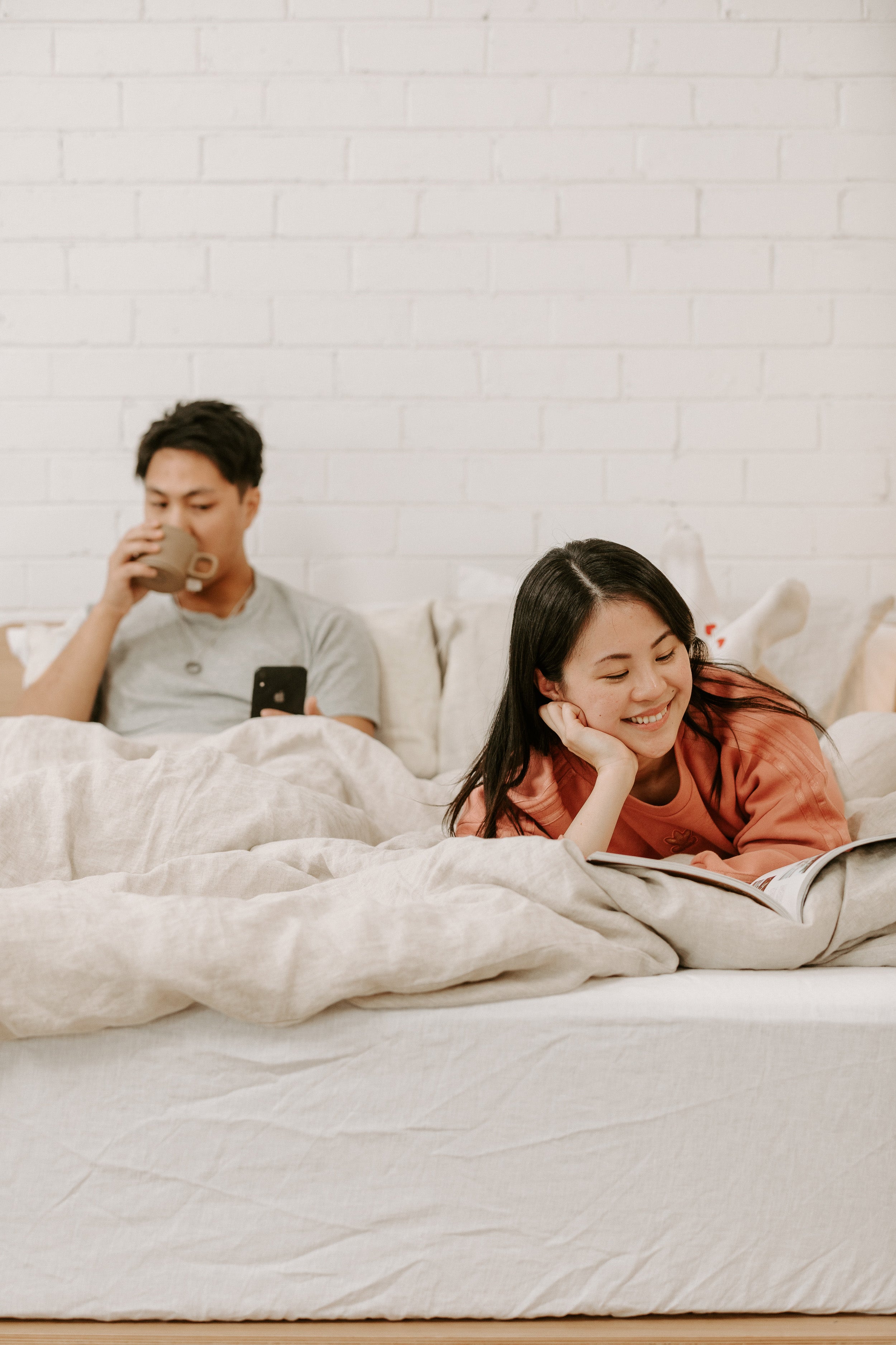 Woman and man lying on bed with Eva hemp linen sheets 