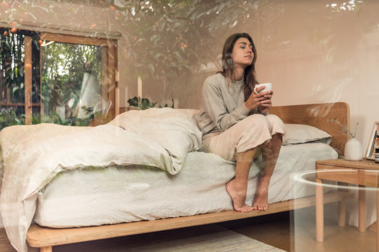 Woman closing her eyes on eva mattress with tea 