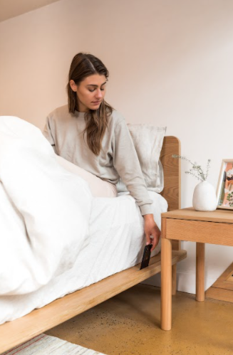 Woman taking phone out of eva bed frame device holder