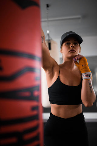 woman boxing with a heavy bag
