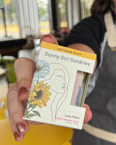 Woman's hand holding Sunny Girl Sundries box of Soap