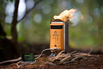 biolite campstove in the woods burning wood and charging a phone