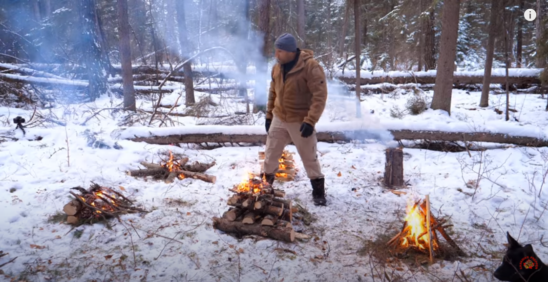 Canadian prepper standing in between the six different types of fire builds: tipi, lean to, torch, cabin, top down and star build