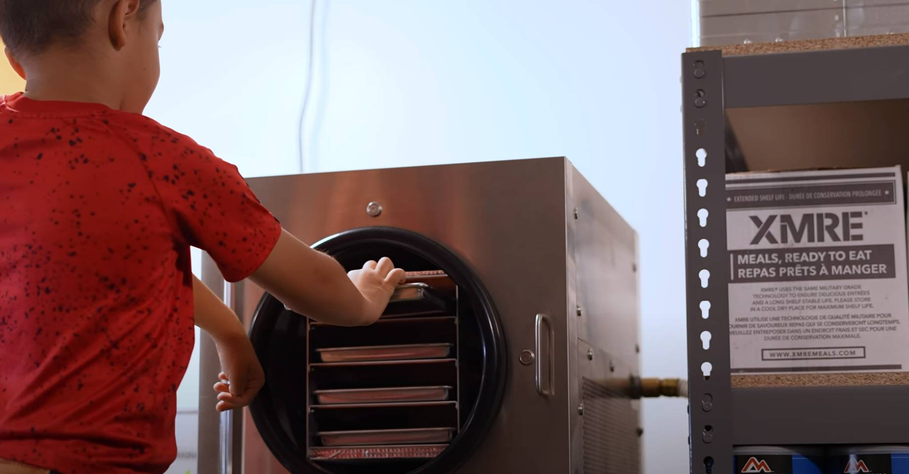 Son placing a tray of food into a freeze dryer