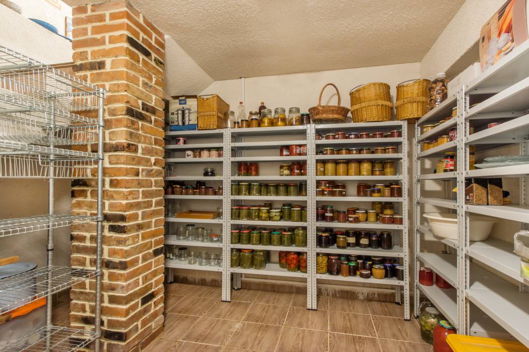 A basement cold room with storage full of food and household goods